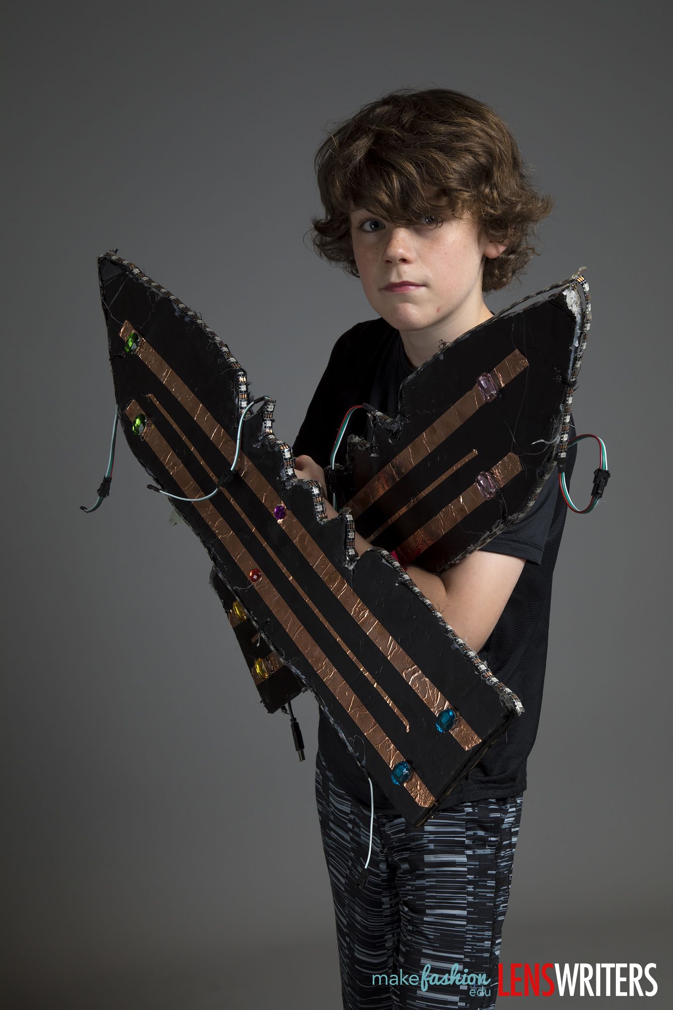 Close-up of student's arms wrapped around a jeweled LED wing