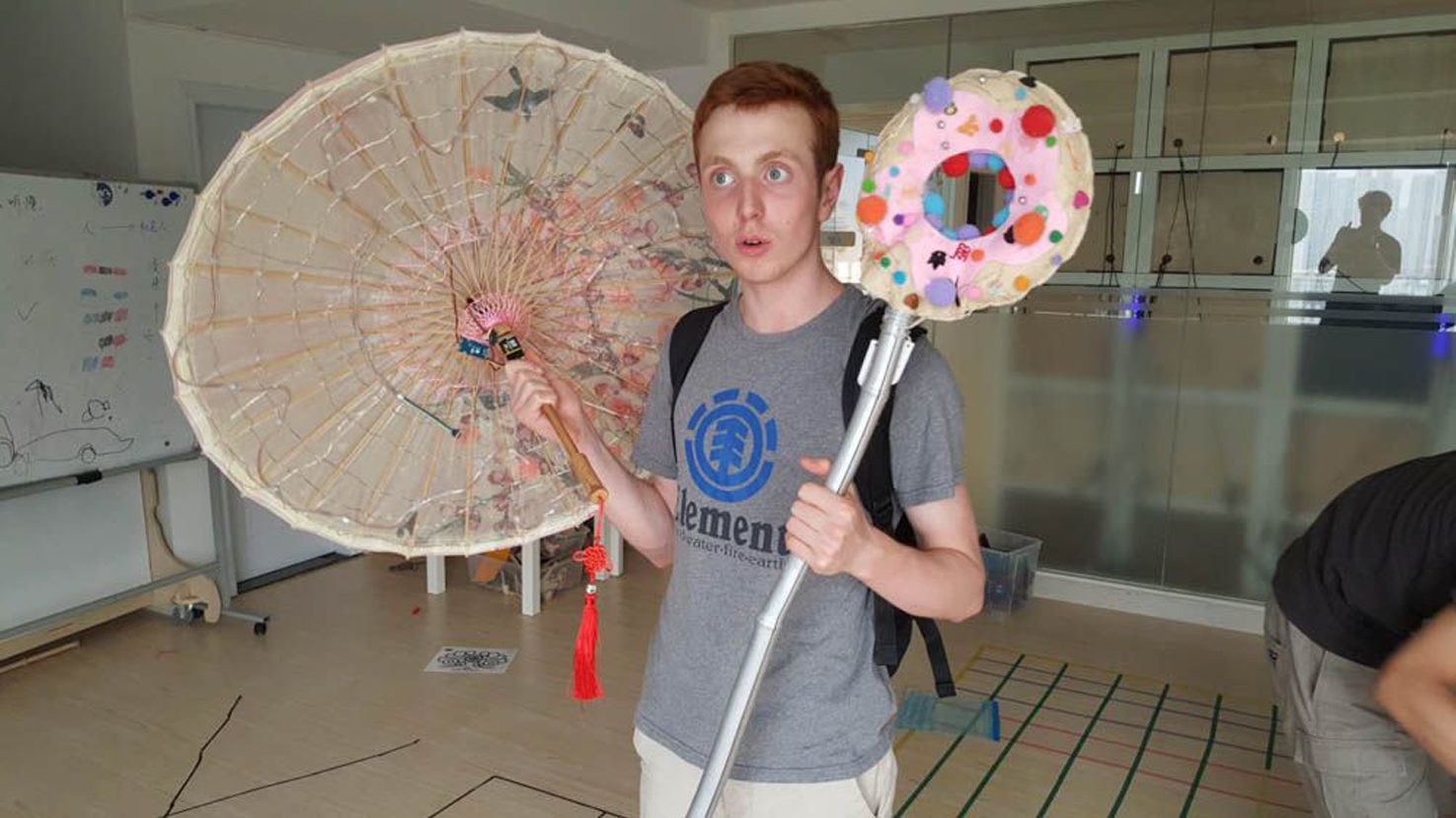 Oliver Child holding a paper parasol and decorated foam wand