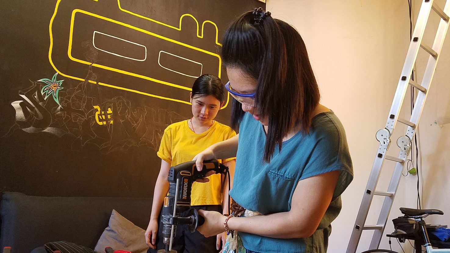 Olivia demonstrating a power drill to another woman