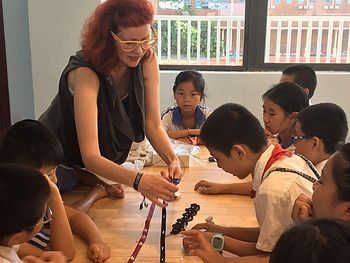 Anina Net demonstrating an electronics project to a group of seated children at a table