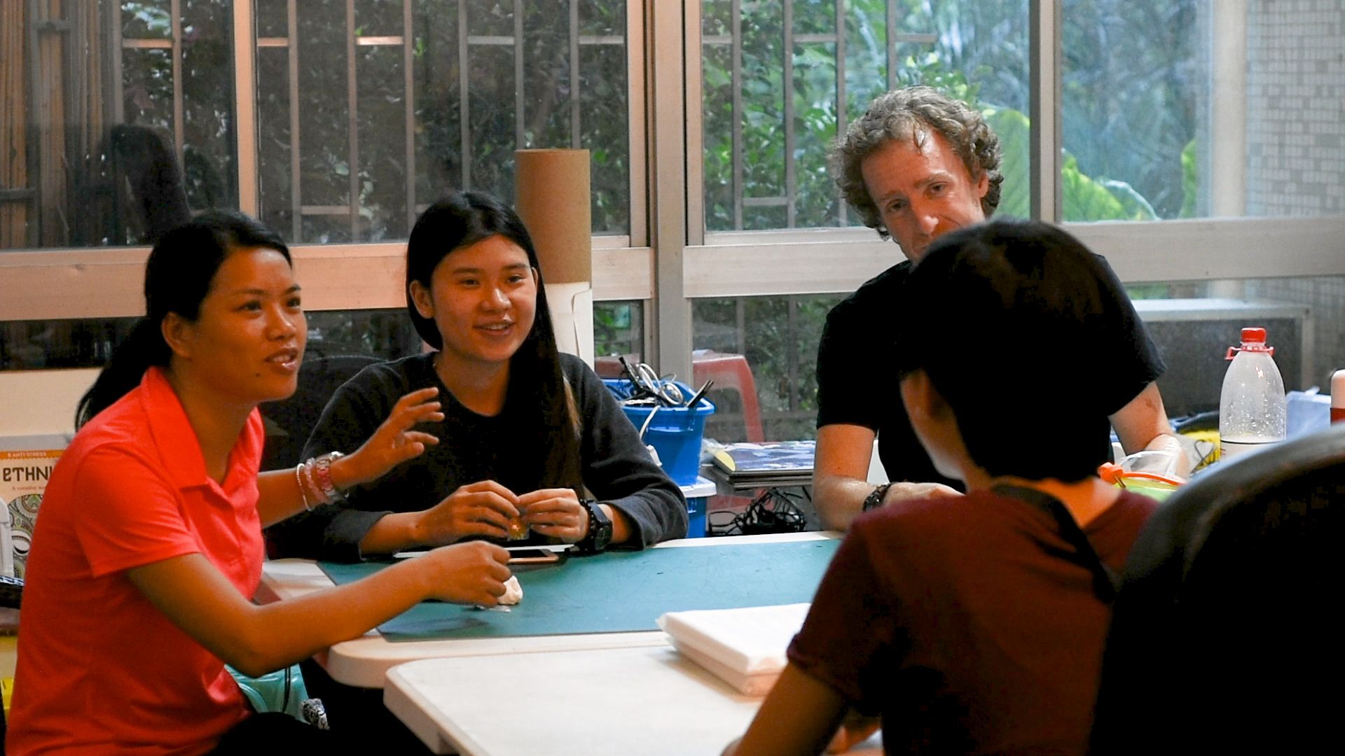 James talking with colleagues and a student at a worktable