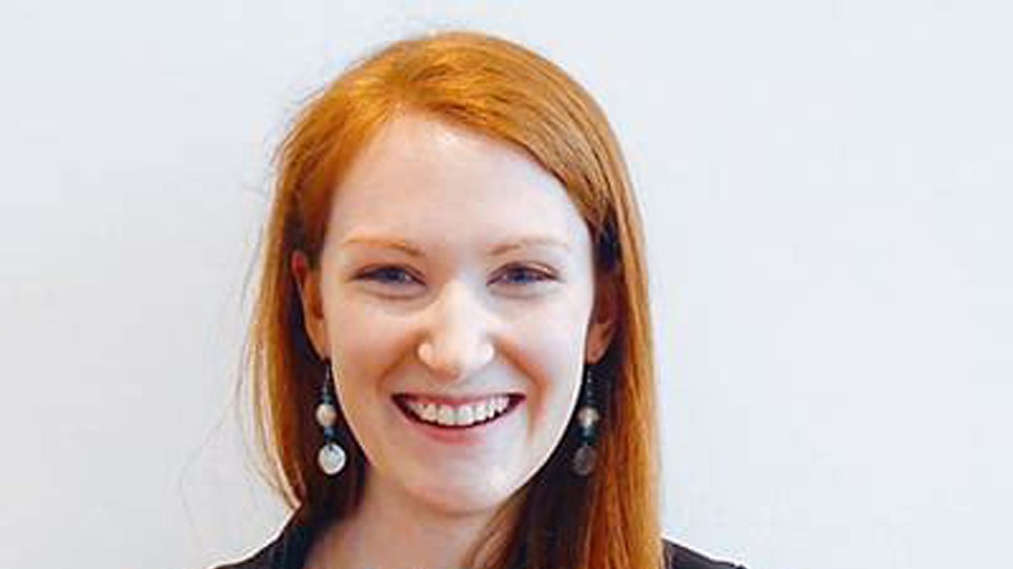 Karen Nemeth smiling in a close-up portrait, wearing dangling earrings