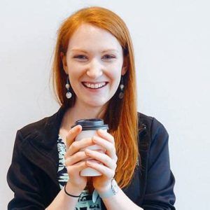 Karen Nemeth holding a to-go coffee cup, smiling in a close-up portrait