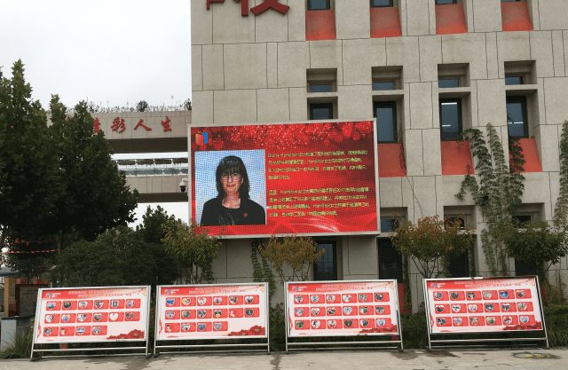 LED screen showing a video greeting outside a school building in Xi'an