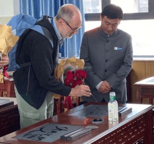 Visitor examining an ink stone at a calligraphy demonstration