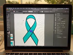 Close-up of a laptop screen displaying a teal ribbon logo design