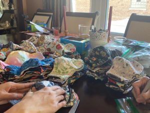 Close-up of colorful handmade fabric face masks piled on a table