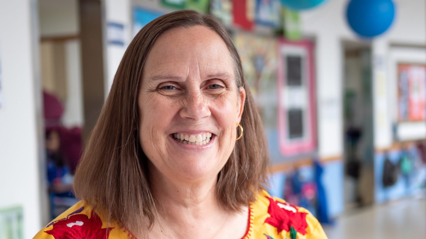 Twila Busby smiling in a decorated school hallway
