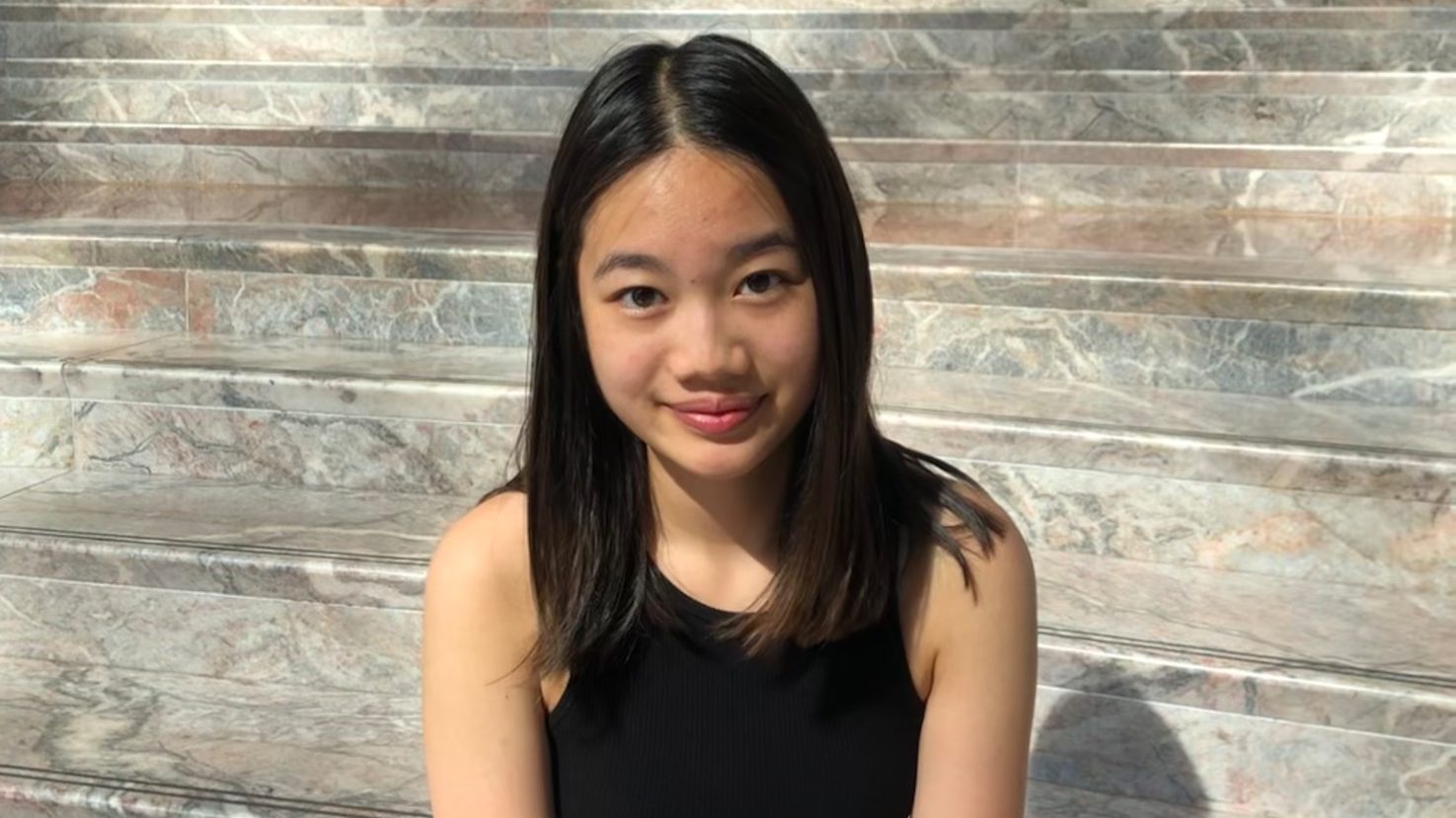 Avery Kuo smiling on a marble staircase
