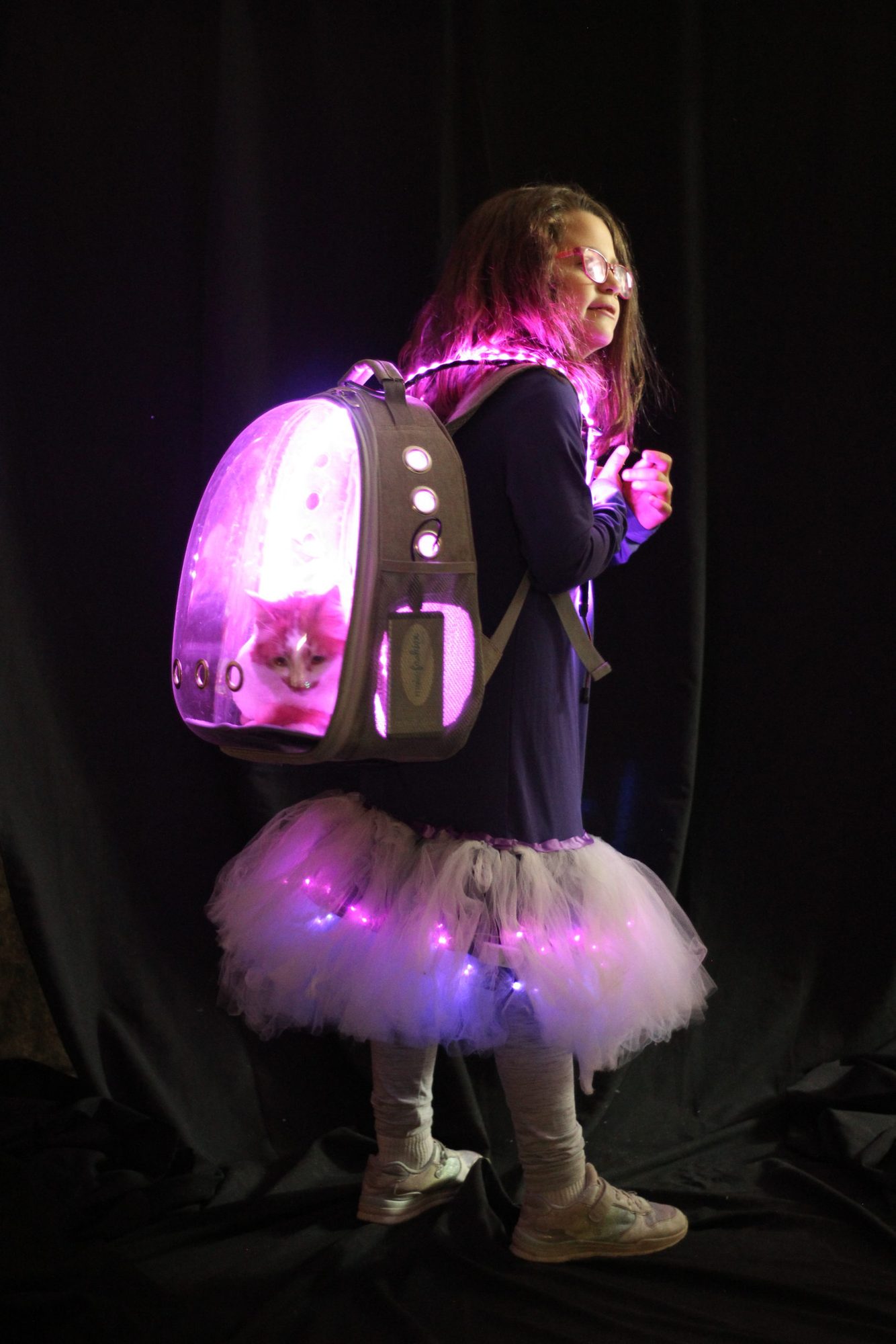 Student modeling a pink LED backpack costume with a cat and light-up tutu