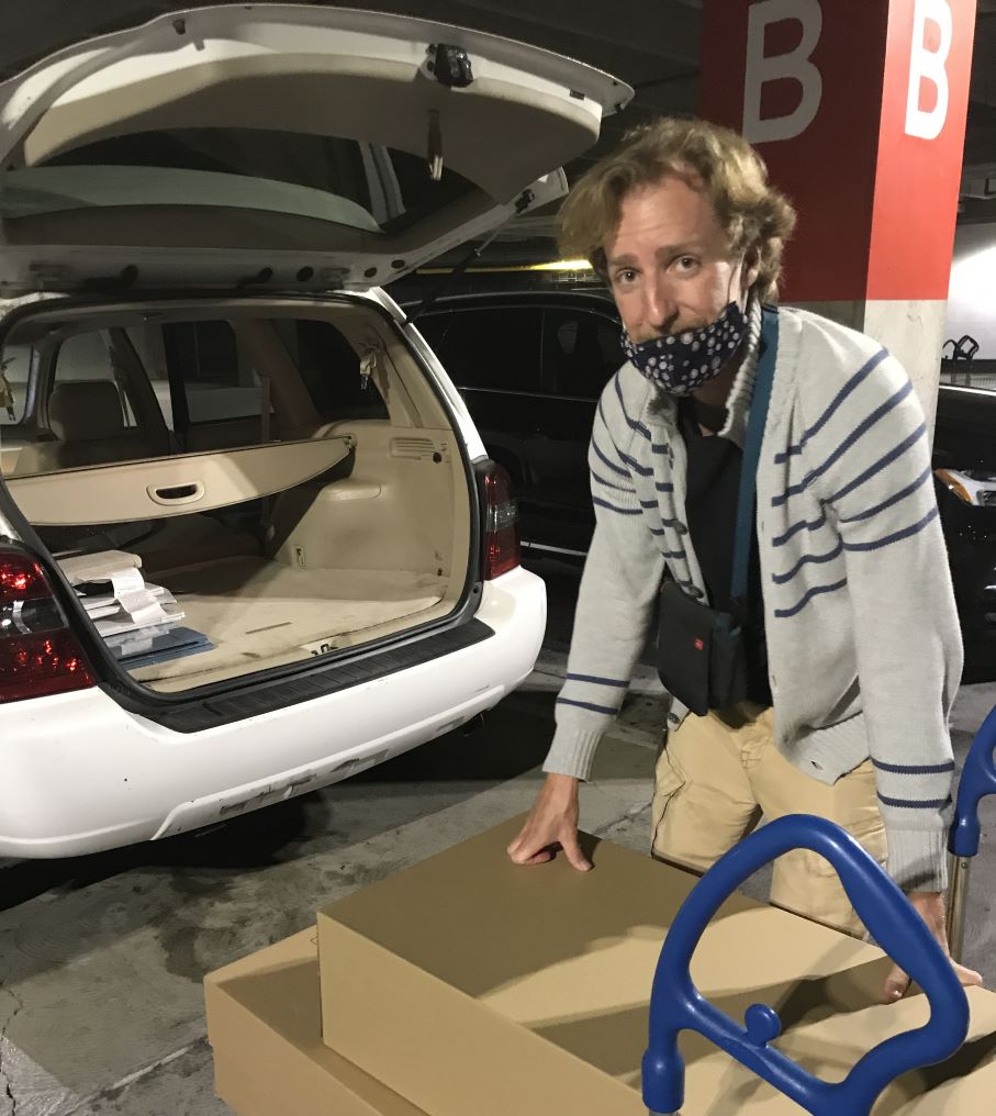 Josh Smith-White loading donated supply boxes into his truck at night