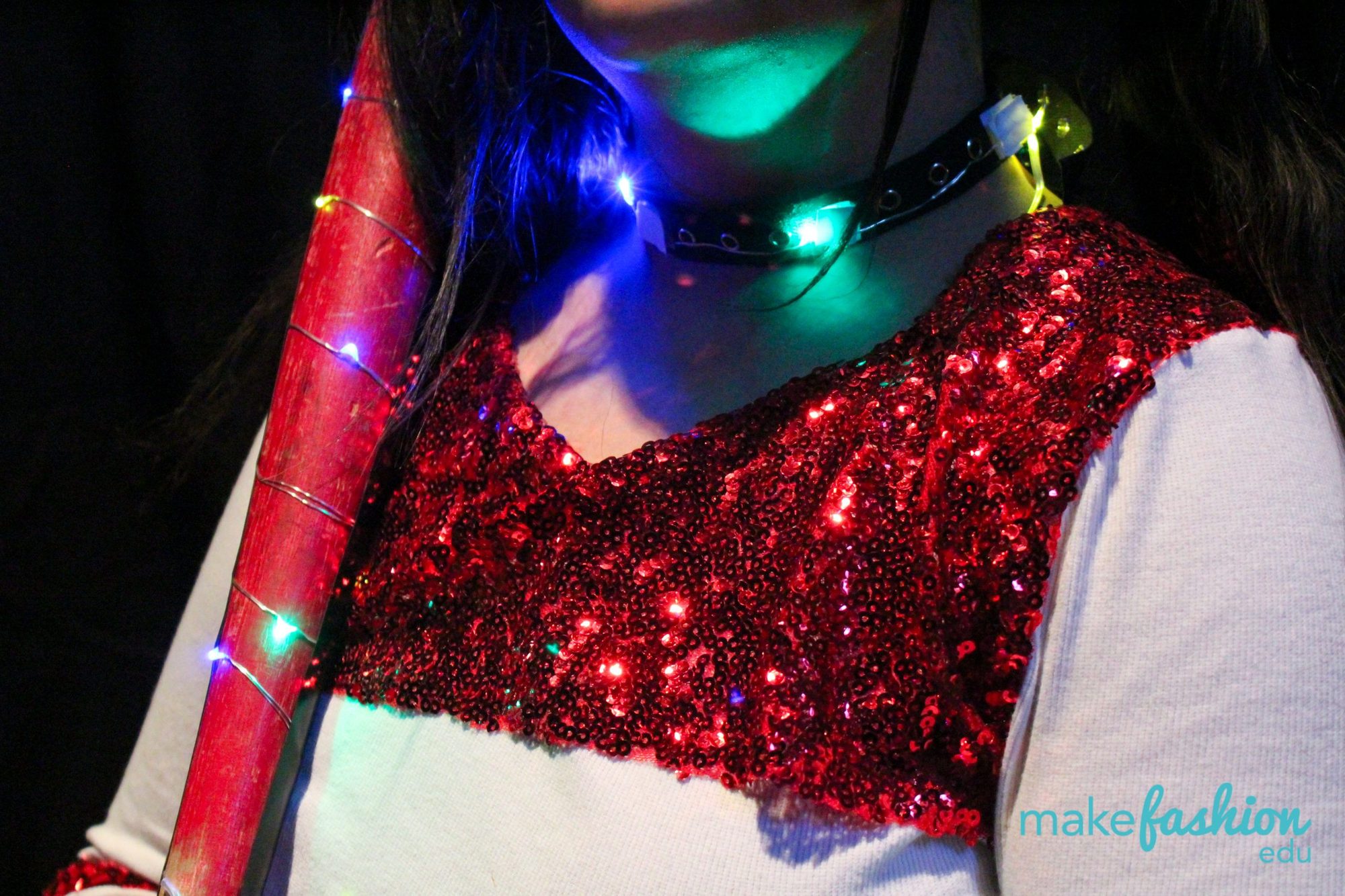 Close-up of a red sequined bodice with a glowing LED choker