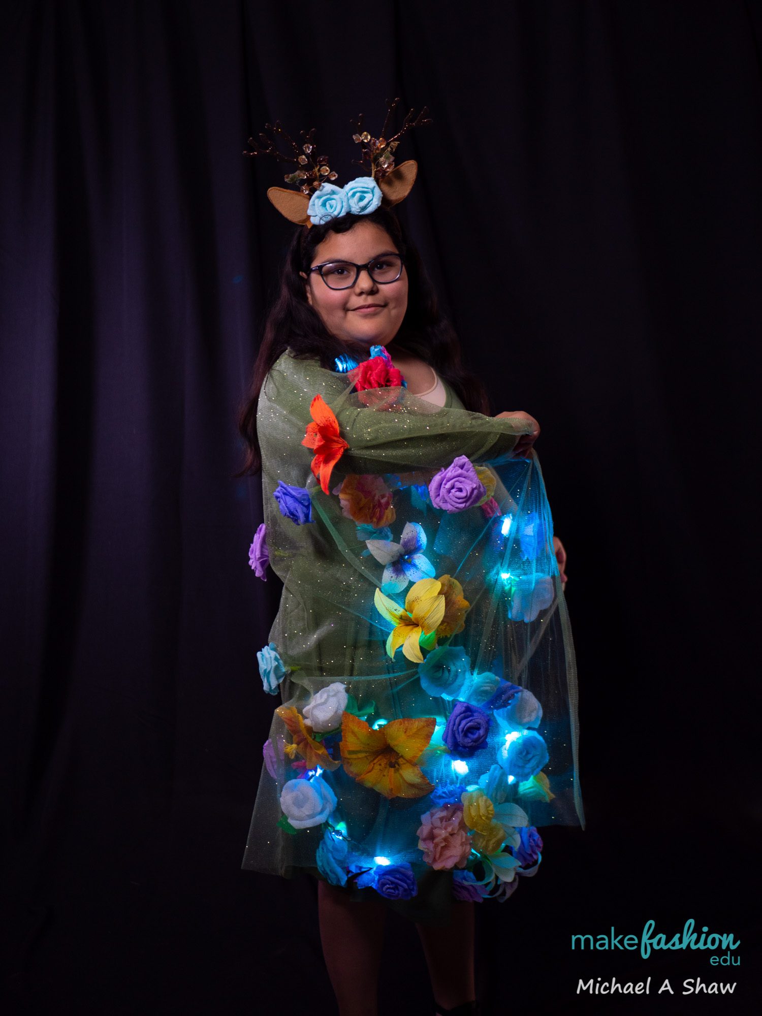Student in embroidered sugar skull mask with colorful floral costume