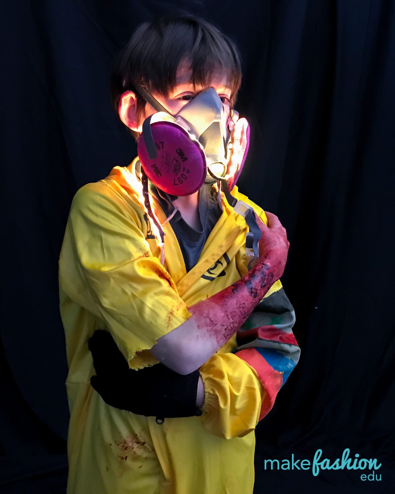 Student in a yellow hazmat suit with a glowing red LED mask