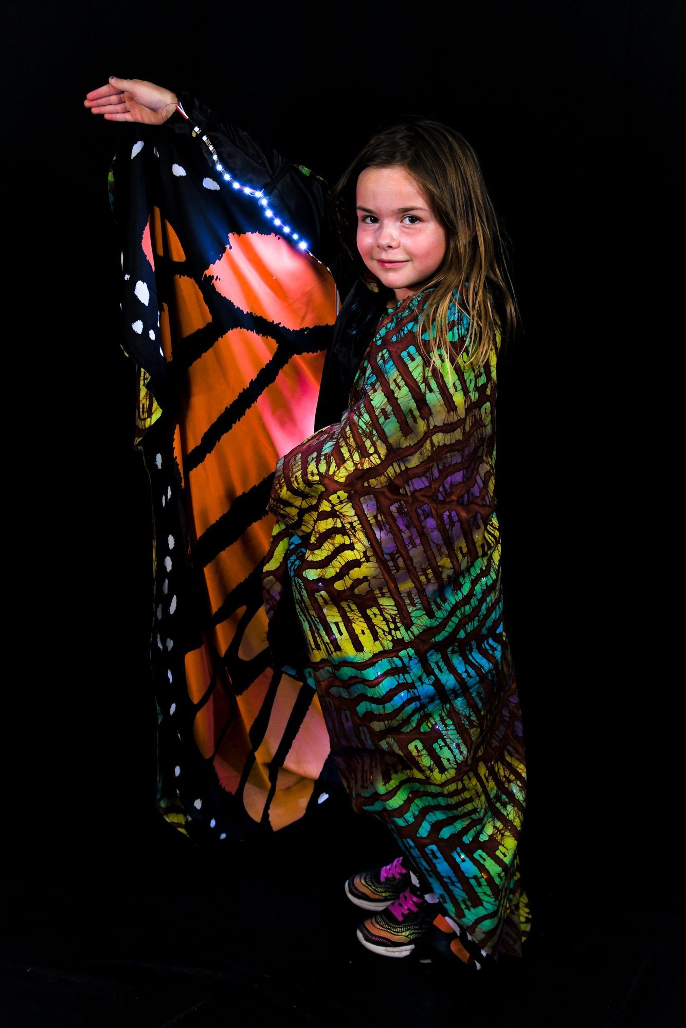 Student holding monarch butterfly wing panel with white LED edge lighting