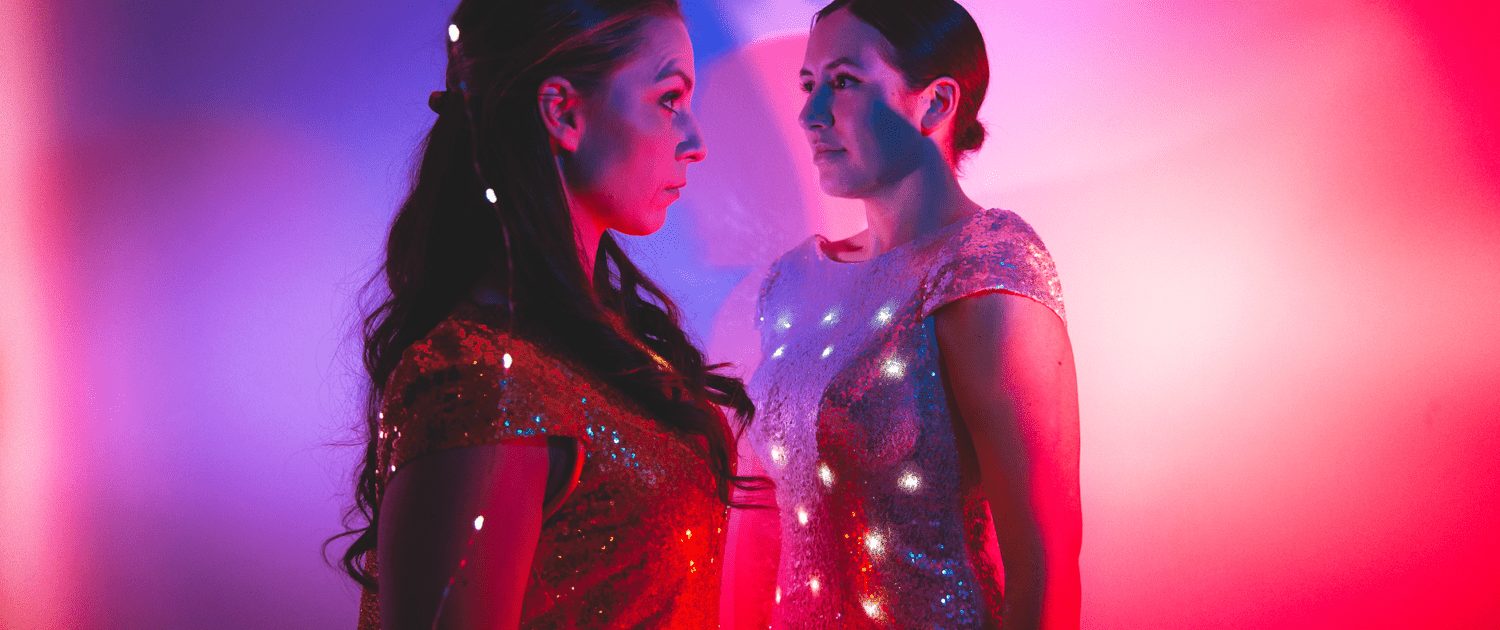 Two students in glowing fashion tech pieces