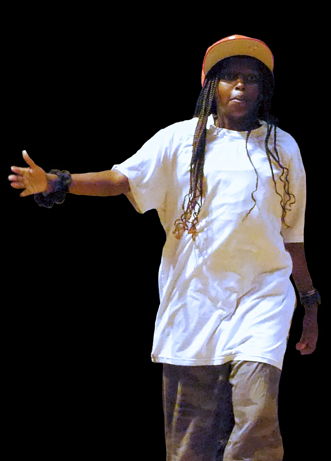 Student as Tyler, the Creator in a white T-shirt and orange cap, reaching out on stage