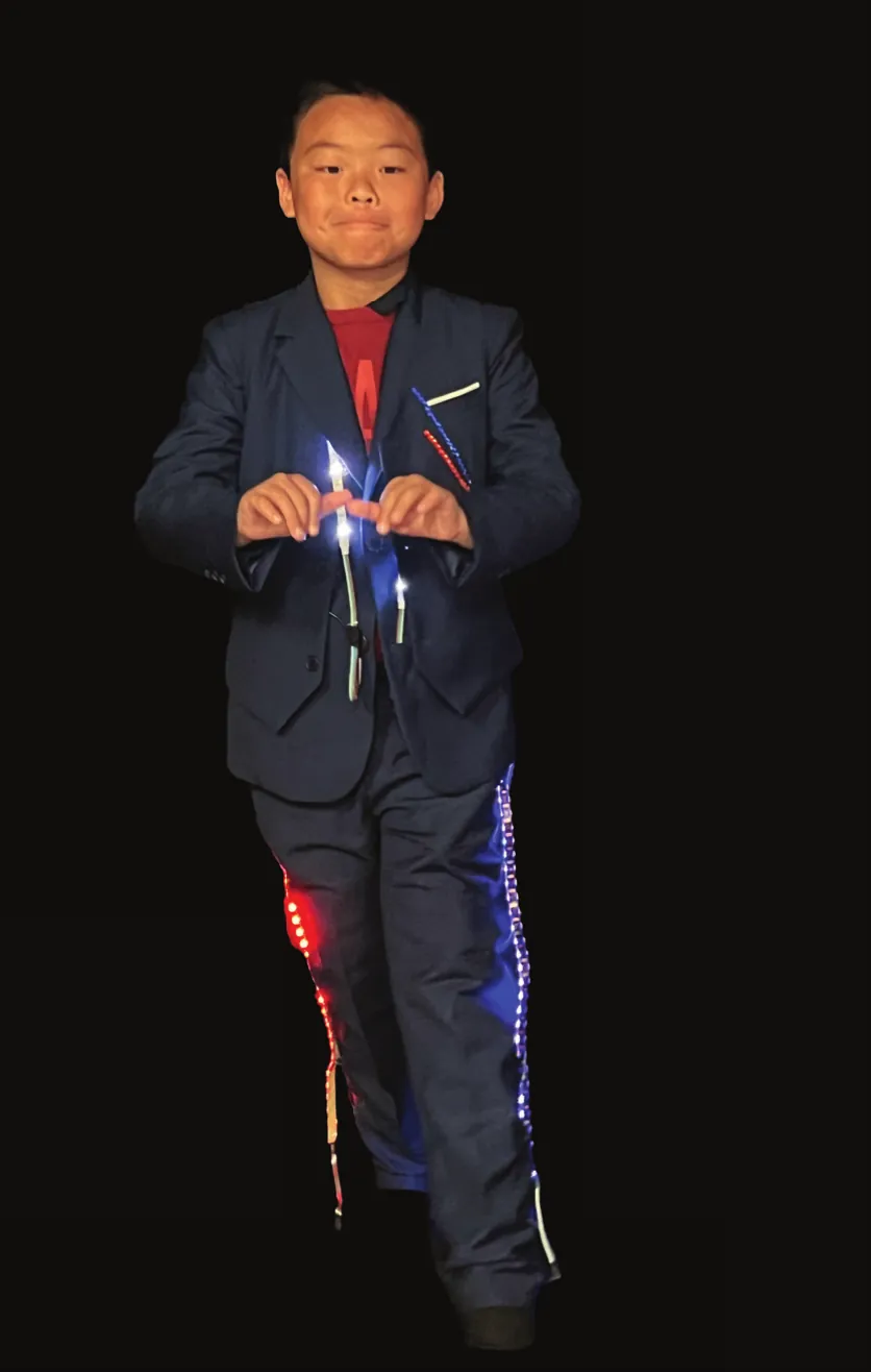 Student as Barack Obama in a dark suit with LEDs running down the trousers