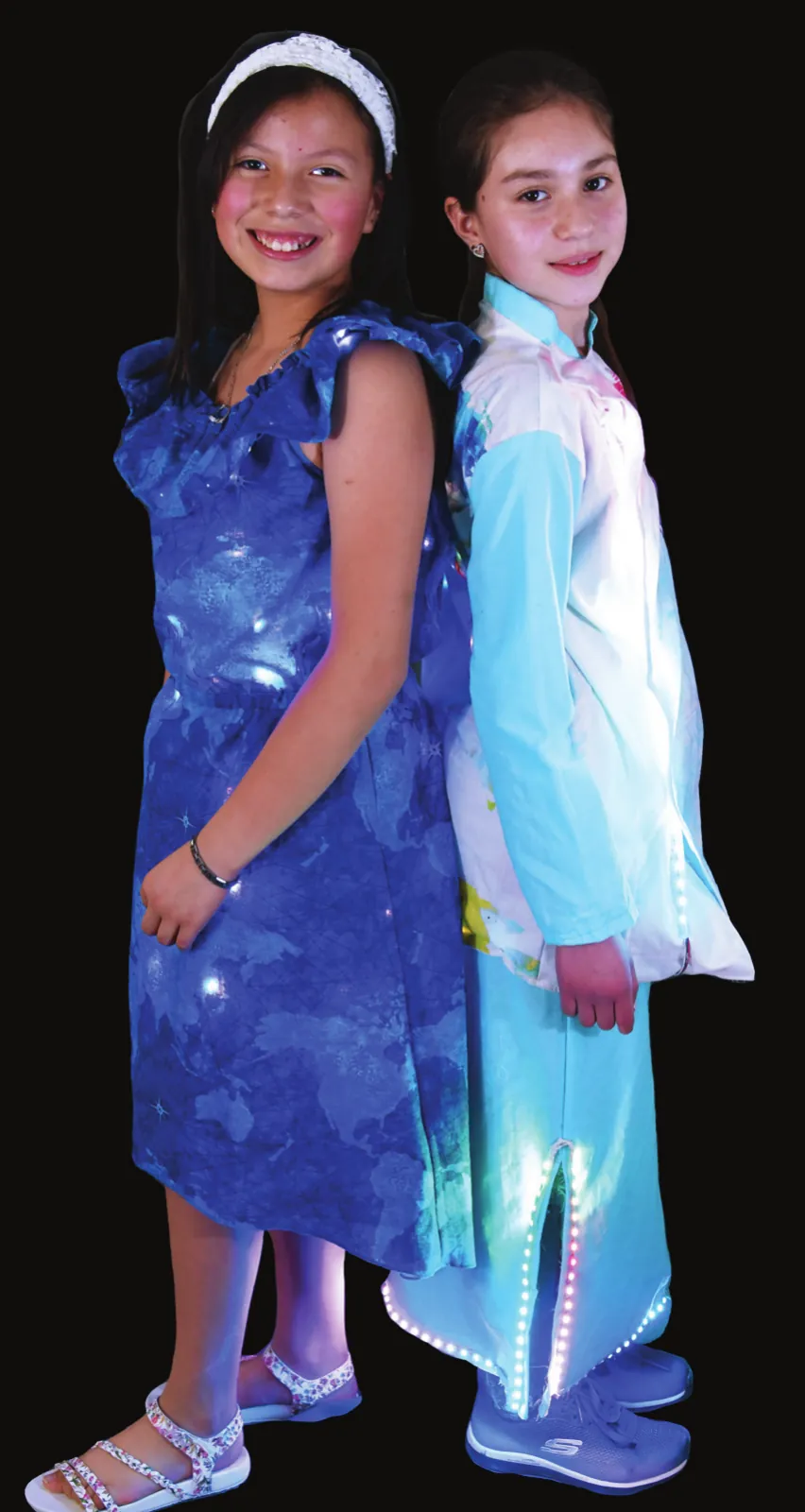 Continental Drift: two students back to back, one in a blue dress and one in a pale blue outfit, both glowing with lights