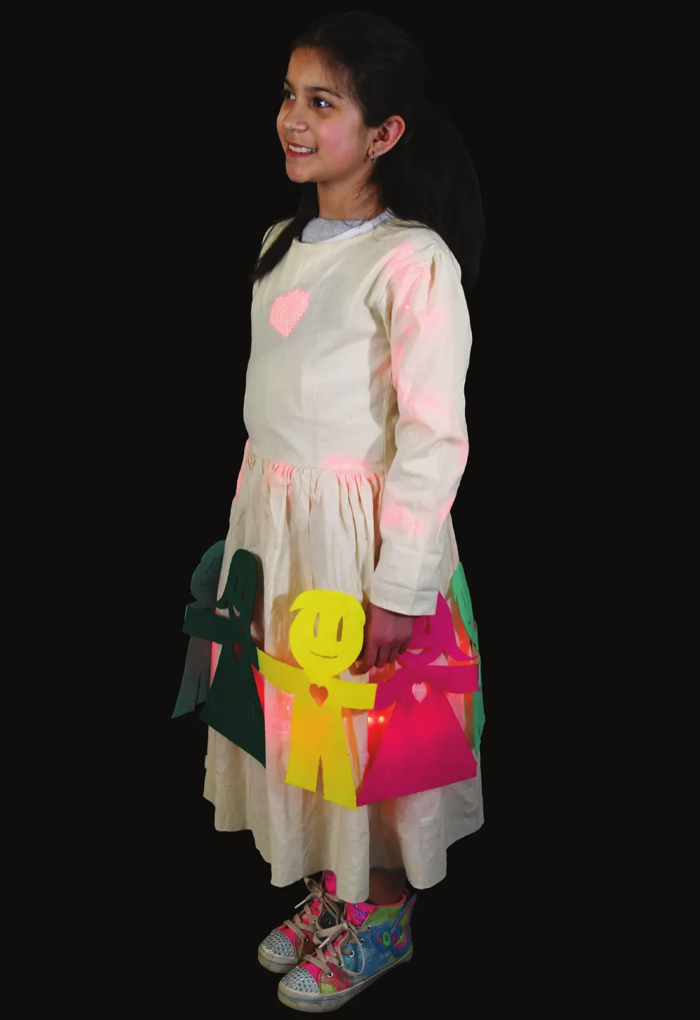 Friends: student in a cream dress decorated with felt cut-out figures holding hands in different colors