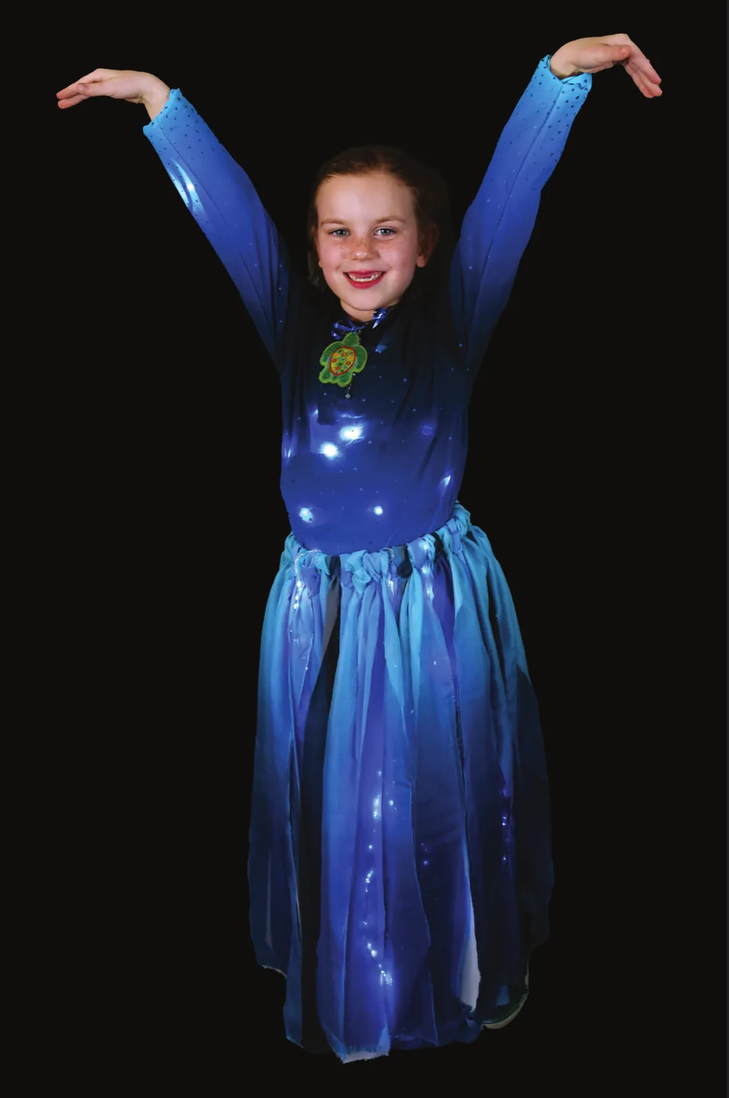 Ocean Waves: student in a blue gown with arms raised in a wave, blue lights glowing through the skirt