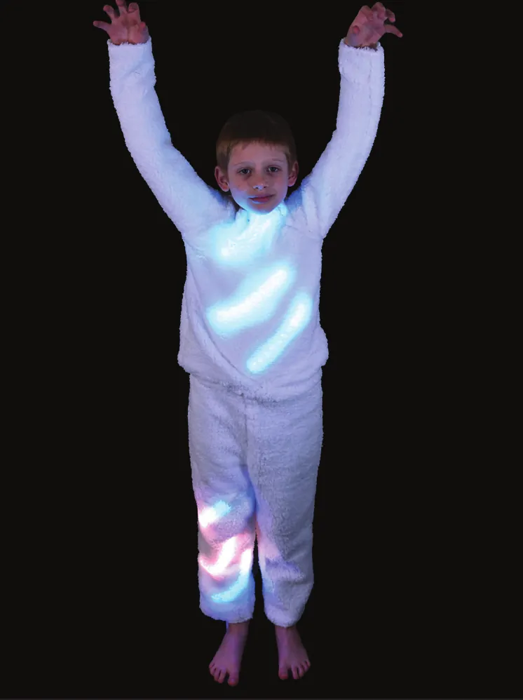Polar Animals: student in an all-white outfit with arms raised, lit from within by white lights