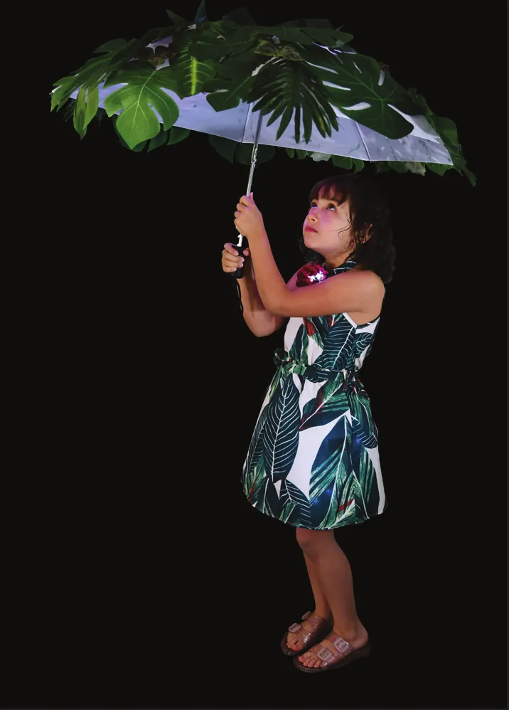 Rain Forest: student holding an umbrella topped with giant tropical leaves, wearing a leaf-print dress