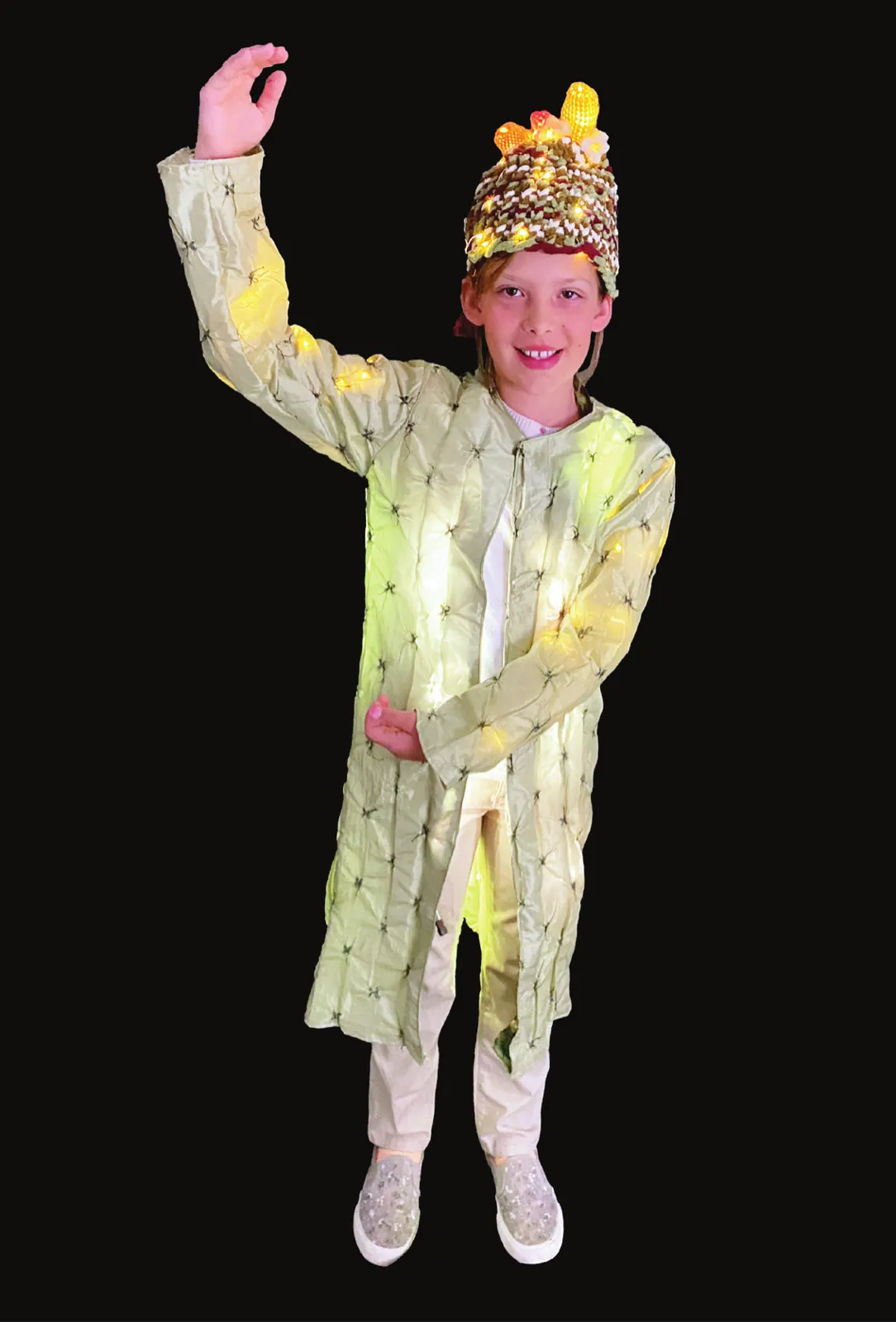 Saguaro Strong: student in a pale green saguaro costume and flowering headpiece, arm raised like a cactus arm