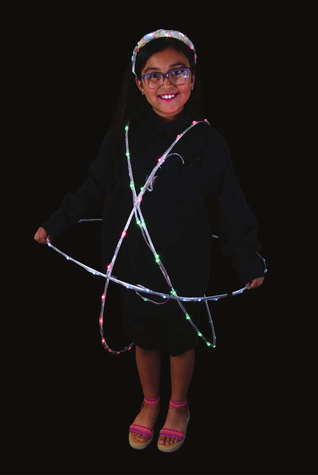 Neighborhoods’ Matter: The Atom: student in black clothes circled by three crossing rings of lights