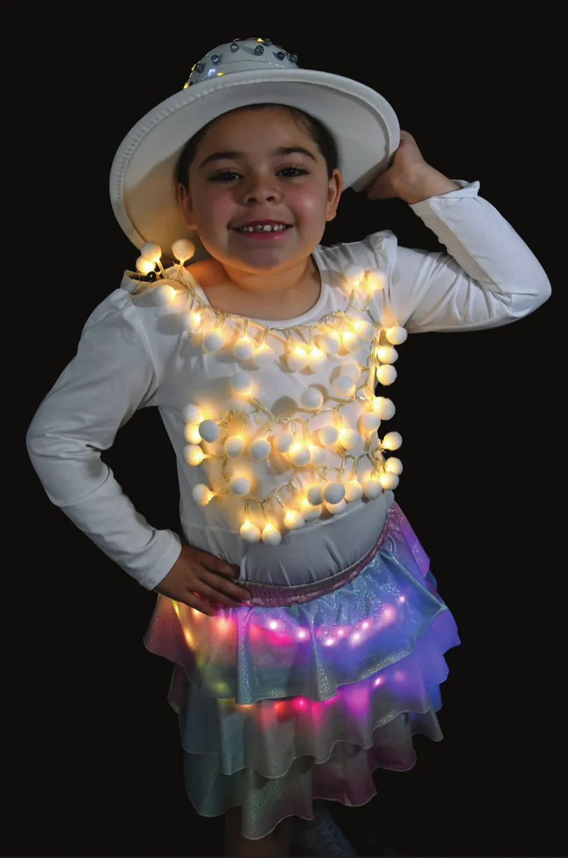 Colors of the Wind: student in a white hat and a top covered in glowing puffballs, over a pastel tulle skirt