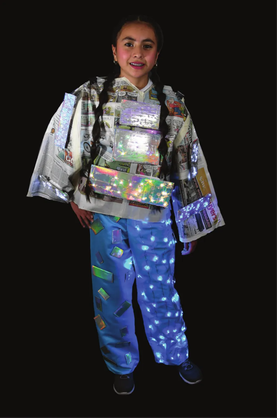 Recycled Rectangles: student in a jacket and pants made of reflective recycled packaging, dotted with lights