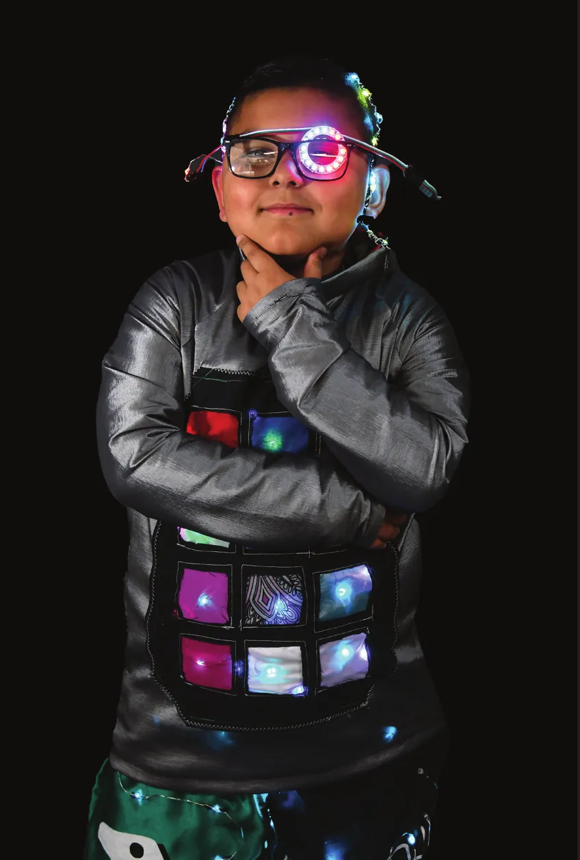 TechConnect: student in light-up glasses and a silver jacket with glowing screen panels on the chest