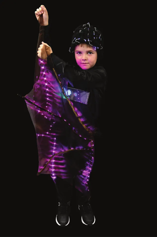 The Bat: student in black spreading wings lit with purple LED strips