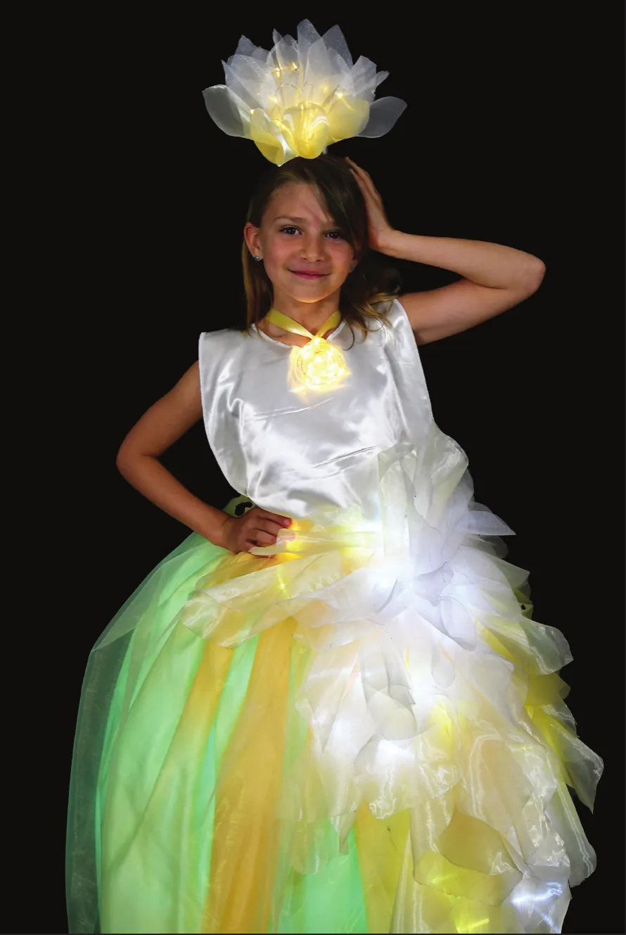 Tubular: student in a glowing white bodice and yellow-green tulle skirt with a lit flower headpiece