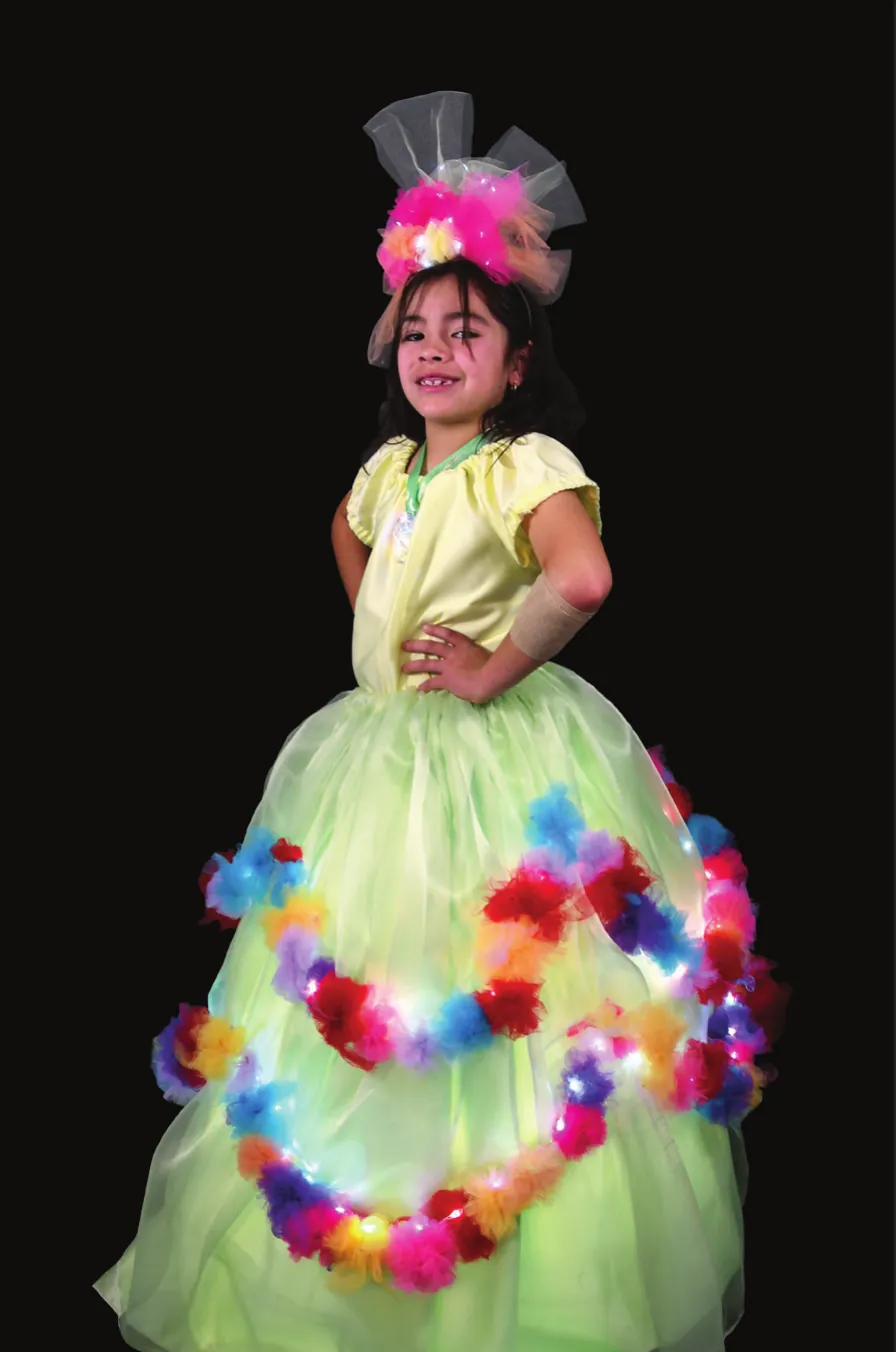 Wildflower: student in a pale green ball gown wrapped with garlands of colorful lit flowers